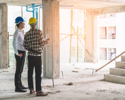 Asian contractor and engineer inspecting material in construction building.